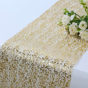 Gold sequin table runner with white roses on a table.