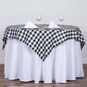 Black and white checkered tablecloth draped over a round table with glasses.