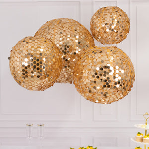Gold sequin disco balls hanging decoratively above a table.