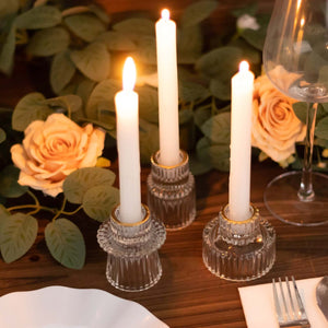 Elegant glass candle holders with white candles and roses for a romantic table setting.