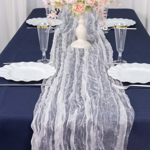 Elegant sheer table runner on a navy table setting with floral centerpiece.