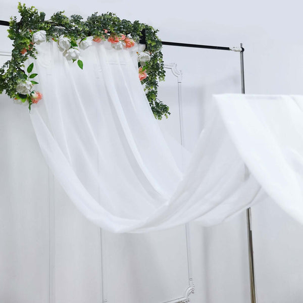 White sheer fabric draped with floral accents on a display stand.