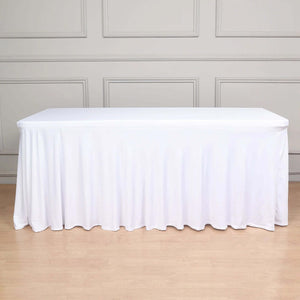 White tablecloth draped over a table in a simple interior setting.