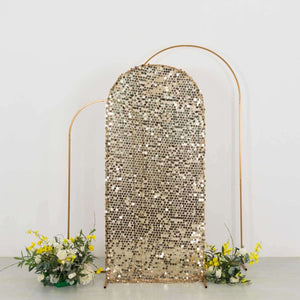 Gold sequin backdrop with arch frame and floral arrangements at the base.