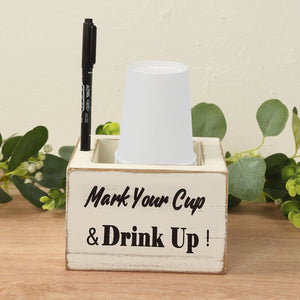 Wooden cup holder with "Mark Your Cup & Drink Up!" text and a pen.