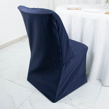 A folding polyester navy blue chair cover sits in front of a white table cloth