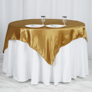 Elevate Your Event with the Gold Square Smooth Satin Table Overlay