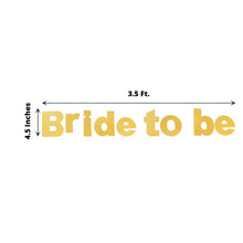 A gold glitter paper bride to be sign that is 3.5 ft long