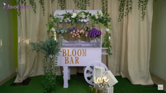 Chic Mother's Day decor featuring a white 'Bloom Bar' cart adorned with flowers.