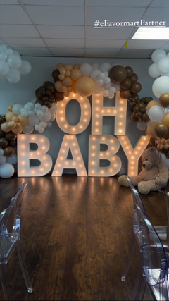 Gender reveal setup with marquee lights and balloon garland