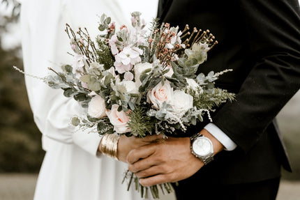 Bride and groom facing each other while holding a bouquet
