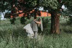 Groom carrying the bride to a barn