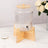 Glass beverage dispenser with wooden stand and lid, perfect for parties.