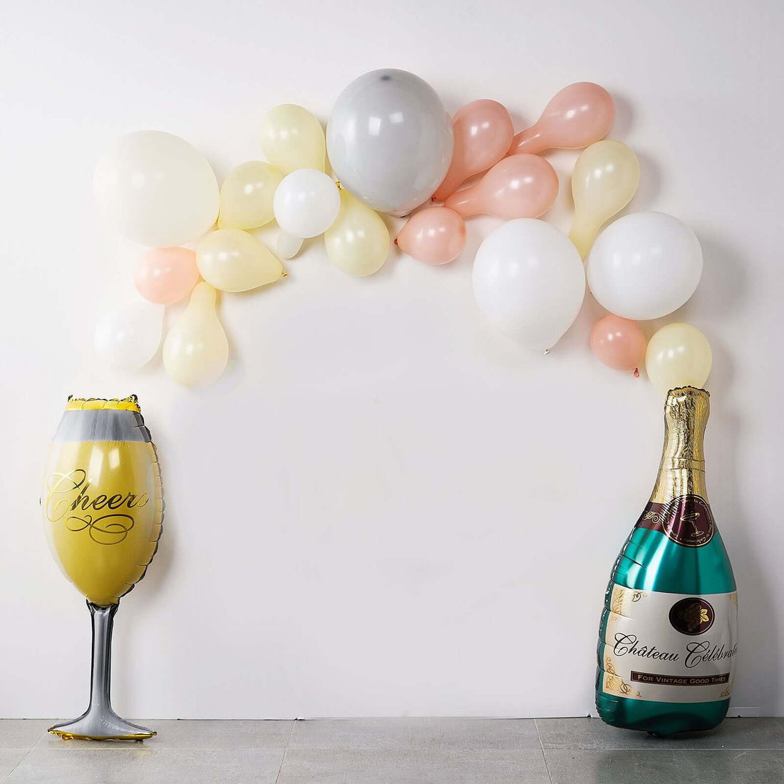 Champagne balloon arch with glass and bottle for celebrations.