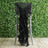 Black chair sash draped elegantly on a high chair against a green backdrop.