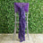 Purple chair sash draped elegantly on a silver chair against a greenery backdrop.