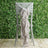 Elegant chair cover with ruffled beige sash against a greenery backdrop.