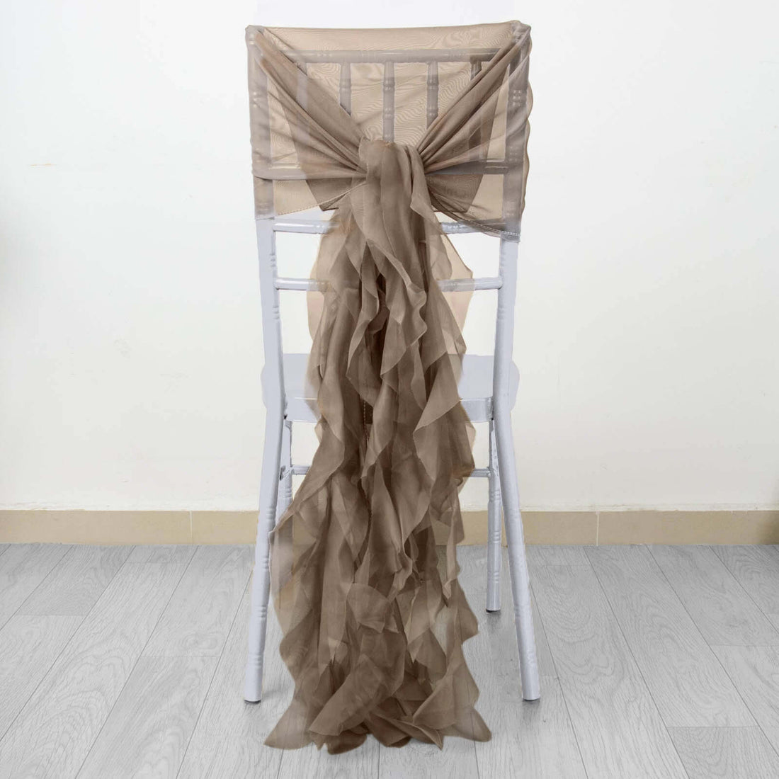 Brown ruffled chair sash draped elegantly over a white chair.