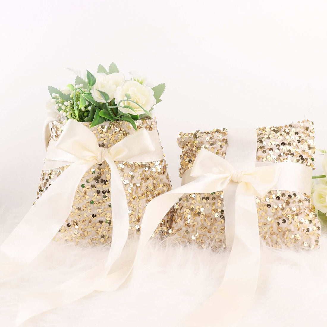 Gold sequin decorative pillows with satin ribbons and floral accents.