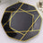Black octagonal plate with gold geometric design.