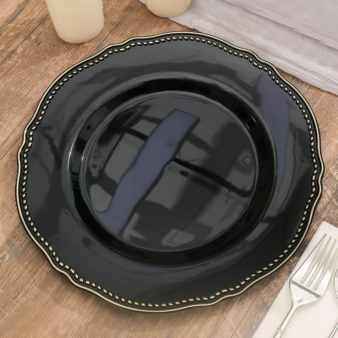 Elegant black plate with gold rim on wooden table surface.