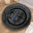 Elegant black plate with gold rim on wooden table surface.