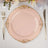 Elegant pink plate with gold detailing on a table setting.
