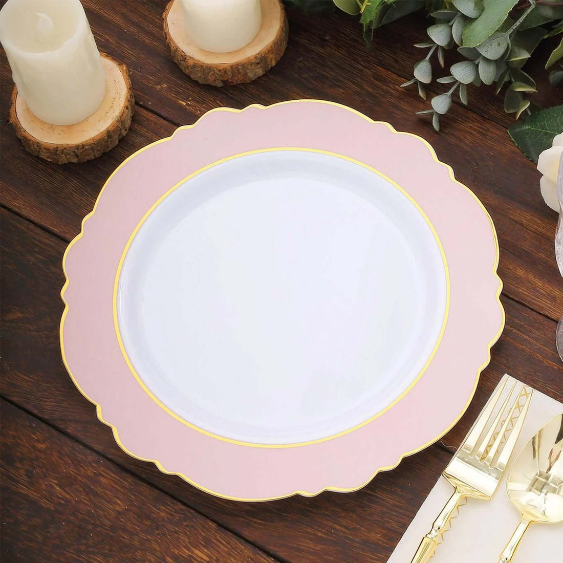 Elegant pink and gold scalloped plate on a wooden table.