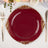 Elegant burgundy dinner plate with gold embellishments on a dining table.