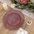 Elegant burgundy plate with gold trim on a rustic wooden table setting.