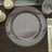 Clear glass charger plate with beaded edges on a wooden table.