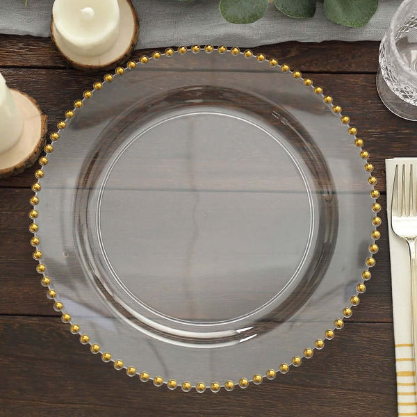 Clear glass plate with gold beaded rim on a wooden table.