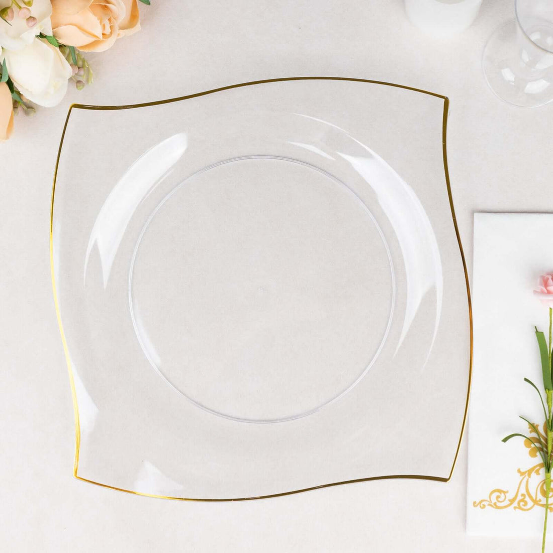 Clear square plate with gold trim on a neutral background.