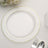 Clear glass plate with gold rim on a table setting.