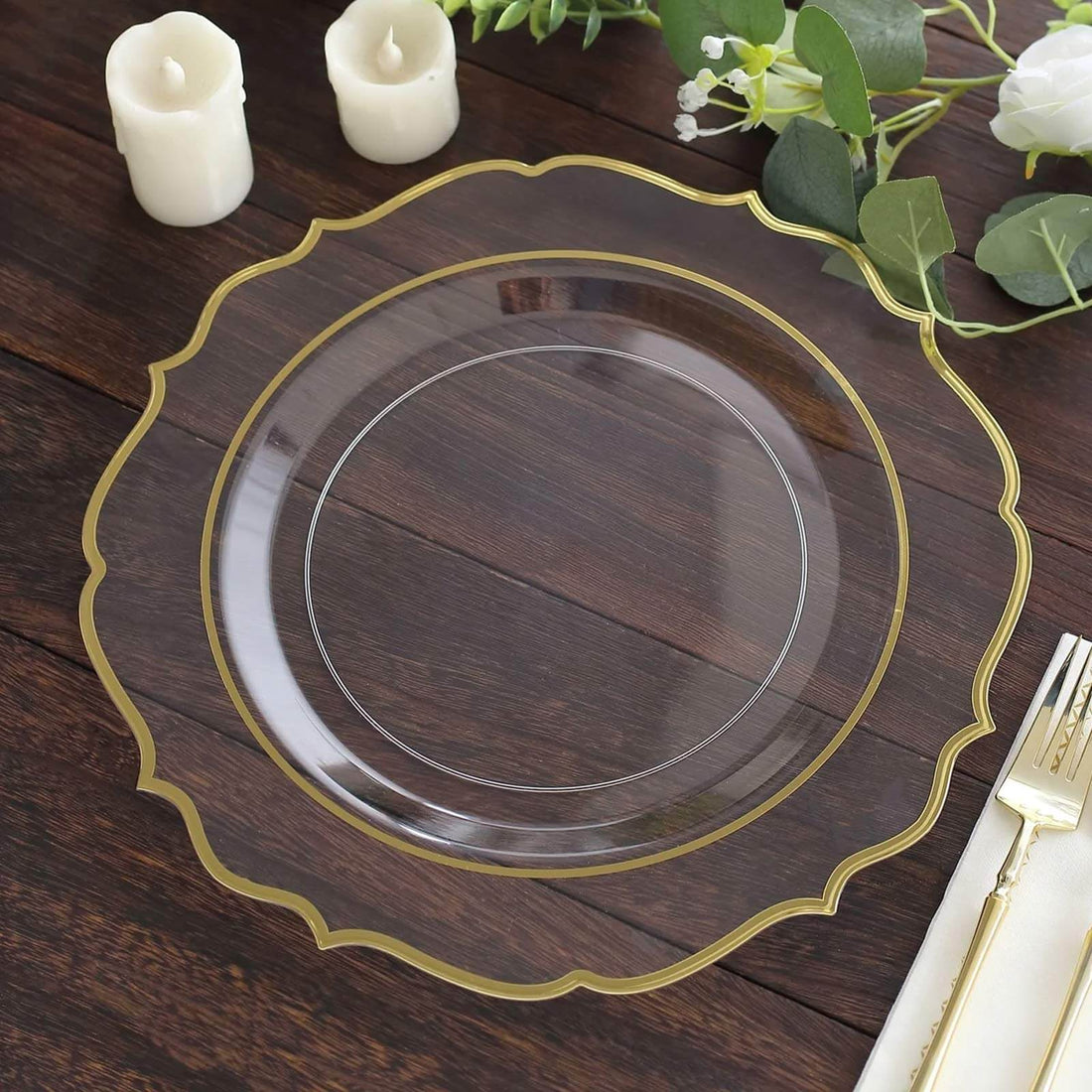 Elegant clear plate with gold rim on a wooden table setting.
