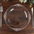 Clear decorative plate on a wooden table with utensils