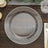 Clear glass plate with decorative beaded rim on a wooden table.