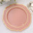Pink decorative plate with gold trim on a textured surface.