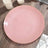 Pink plate with gold trim on a wooden surface.