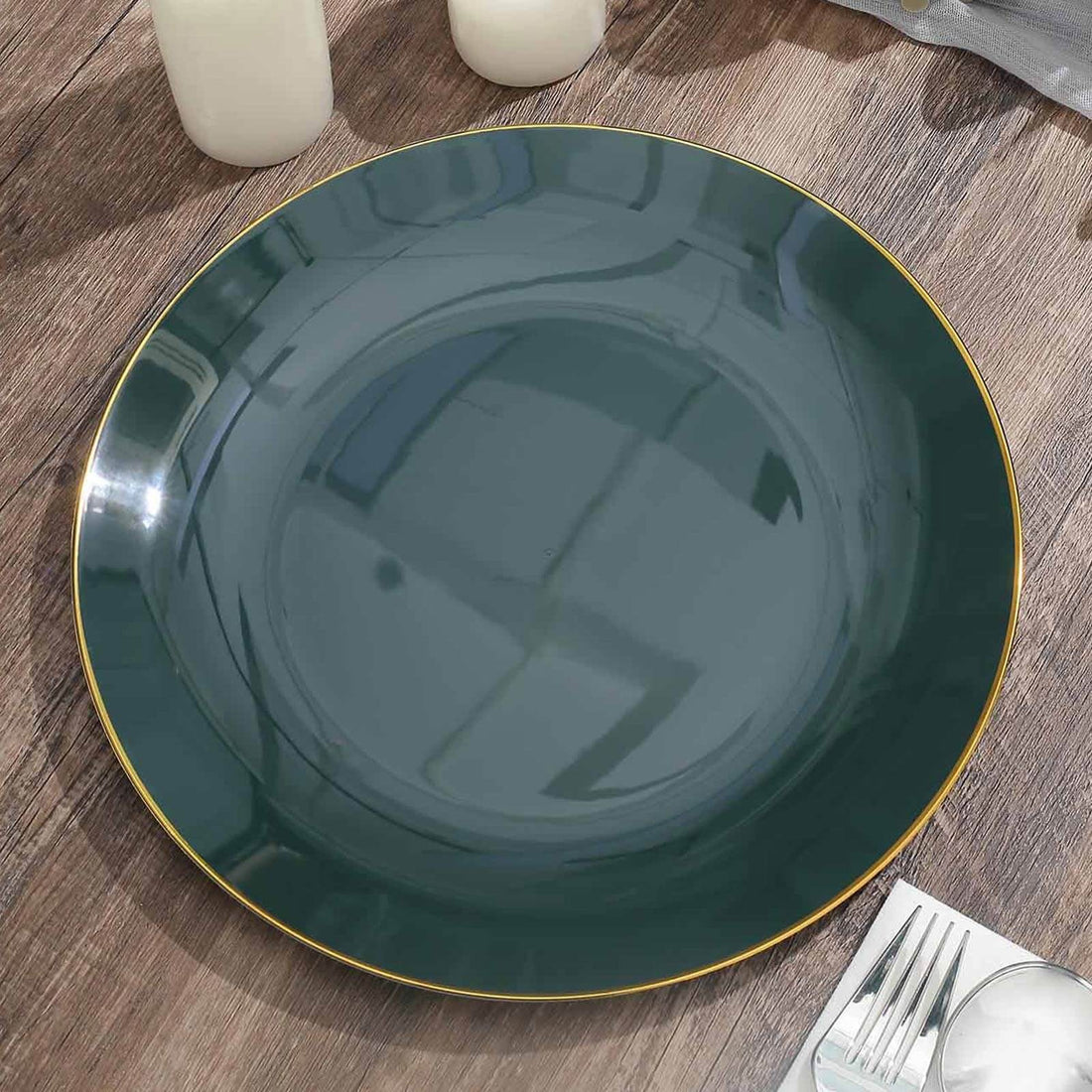 Green decorative plate with gold rim on wooden surface.