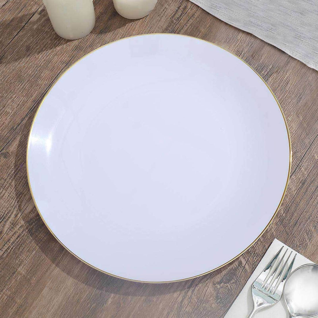 Elegant white plate with gold rim on wooden table surface.
