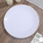 Elegant white plate with gold rim on wooden table surface.