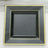 Black square plate with a yellow rim, studio shot.