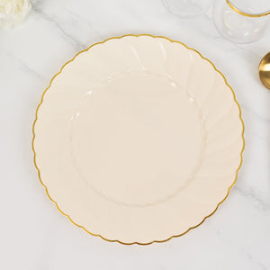 Elegant cream plate with scalloped edge and gold trim on a marble surface.