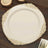Elegant decorative plate with gold trim on a wooden table.