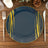 Navy blue plate with gold accents on a wooden table setting.