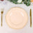Elegant peach dinner plate with decorative rim, styled with gold utensils.