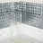 Mirrored tile backsplash in corner with champagne flutes on marble countertop.
