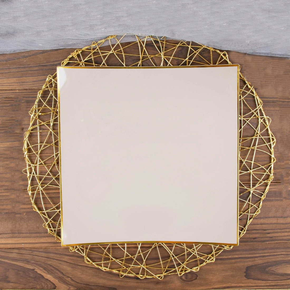 Square ceramic plate on a decorative gold wire charger.