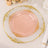 Elegant pink and gold decorative plate on a table setting.